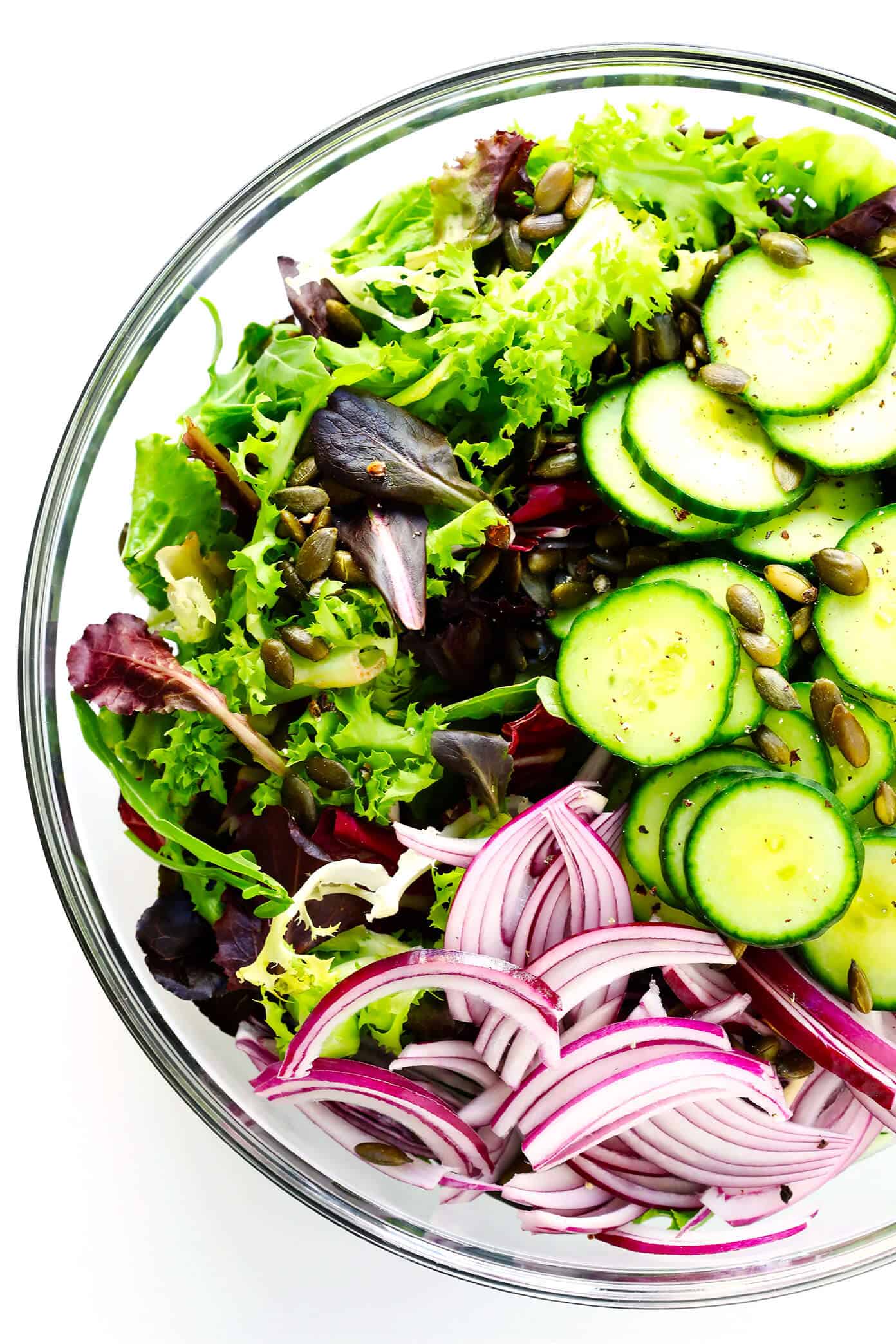 My favorite everyday salad recipe -- made with fresh greens, cucumber, red onion, pepitas (or your favorite nuts), and a simple lemon salad dressing. So easy, healthy and delicious! | gimmesomeoven.com #healthy #salad #recipe #dinner #vegetarian #vegan #glutenfree #easy #dressing #vinagirette Everyday Salad Ingredients in Salad Bowl