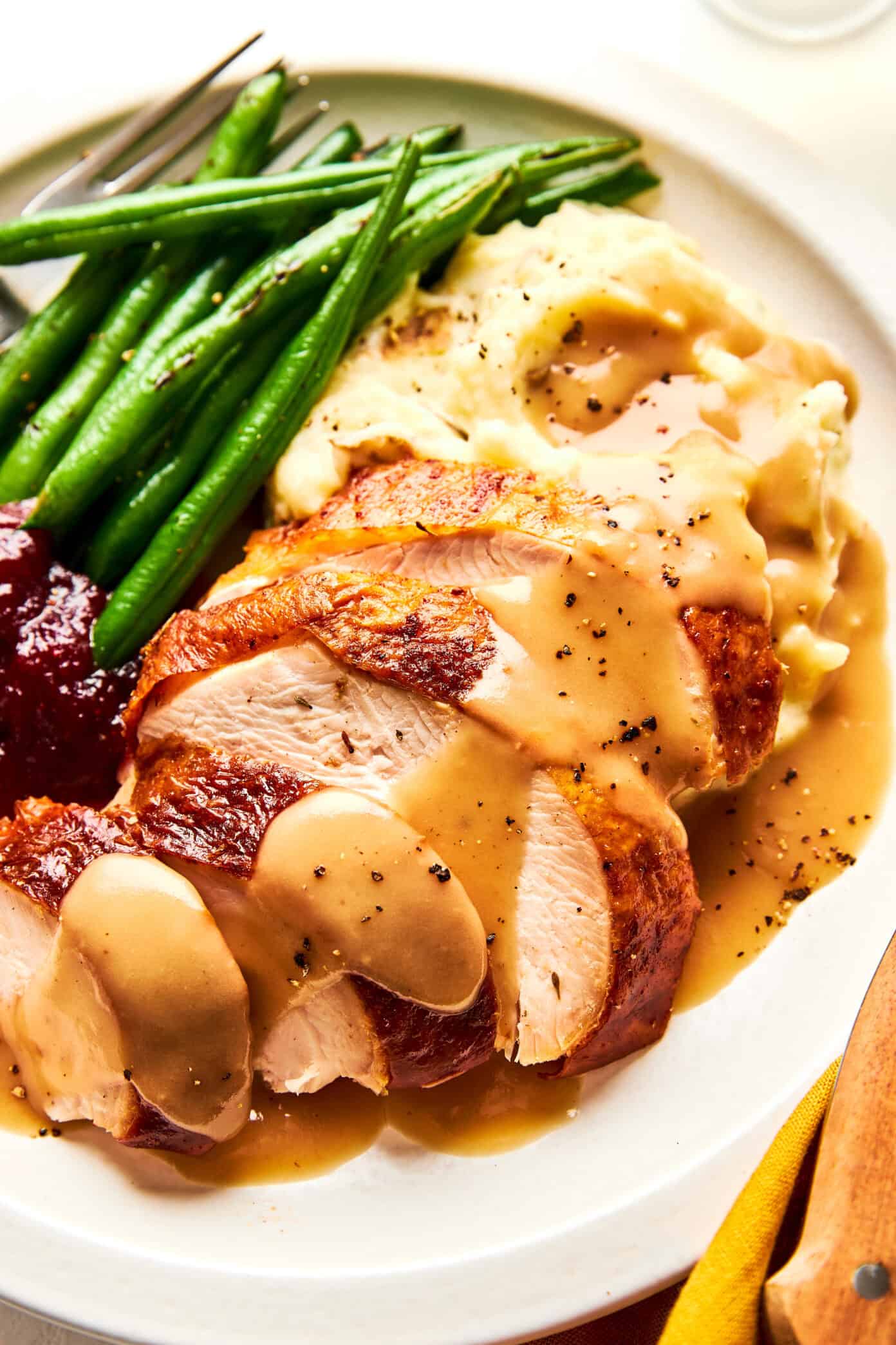 thanksgiving turkey dinner with gravy, mashed potatoes, green beans and cranberry sauce