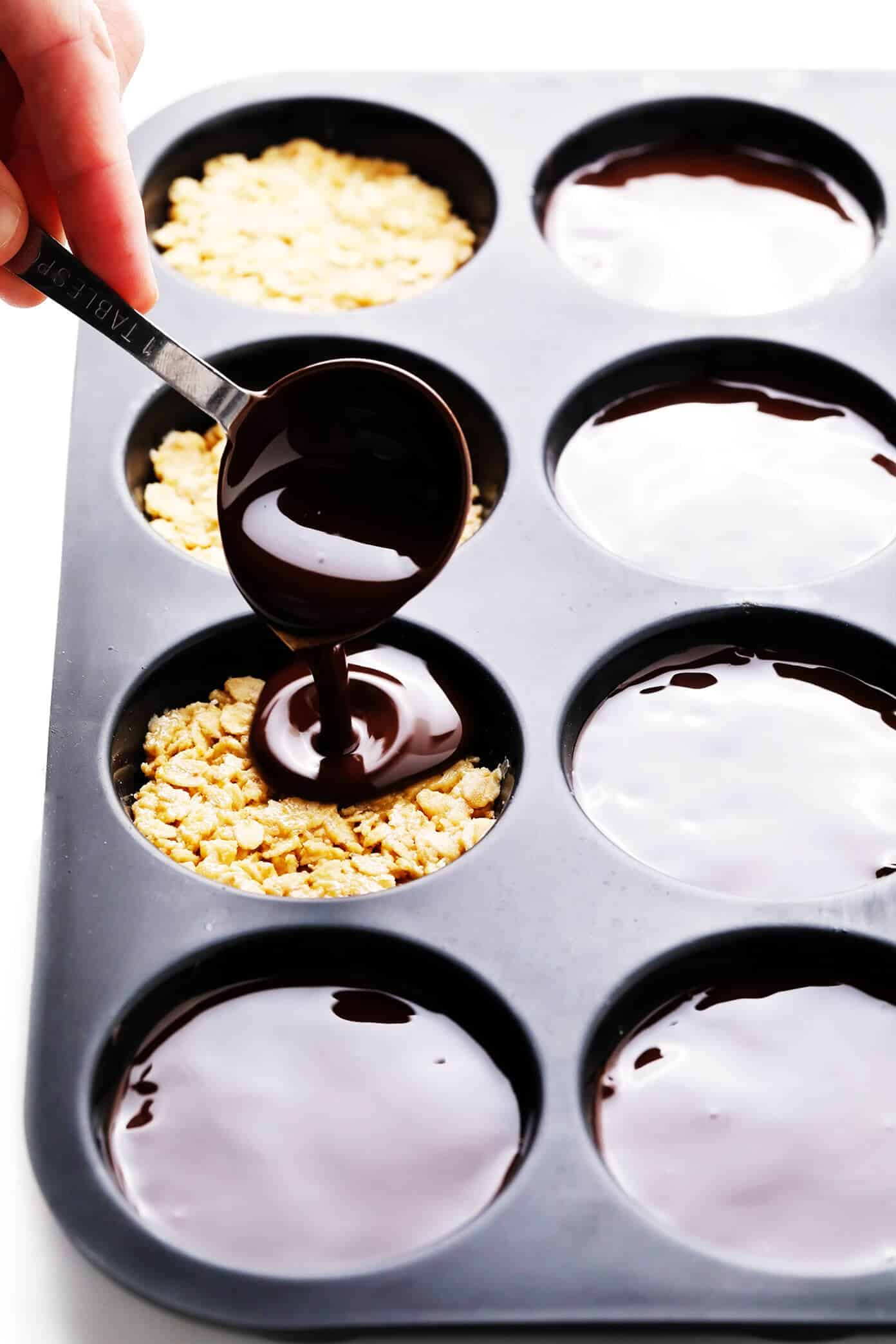 These salted chocolate peanut butter oat cups are quick and easy to make, naturally sweetened with honey, and always SO tasty! They are the perfect treat for breakfast, dessert, or a healthy snack. And they are gluten-free and vegan too! | gimmesomeoven.com Drizzling Chocolate onto Salted Chocolate Peanut Butter Oat Cups
