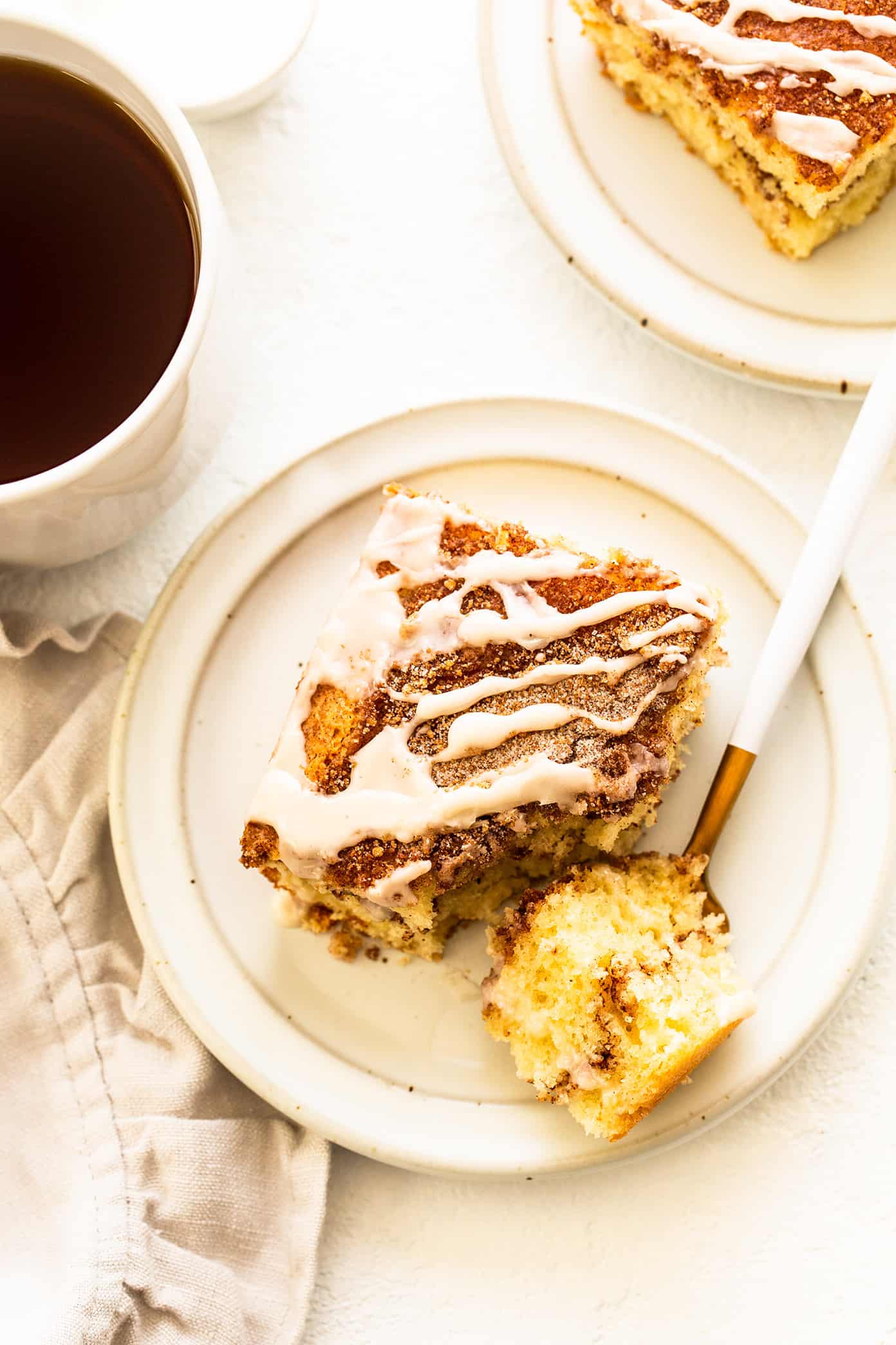 My favorite sour cream coffee cake recipe is perfectly soft and fluffy, layered with cinnamon sugar, and always so delicious. It's the perfect sweet treat for breakfast, snack or dessert, and always so nostalgic and comforting. | gimmesomeoven.com Slice of sour cream coffee cake